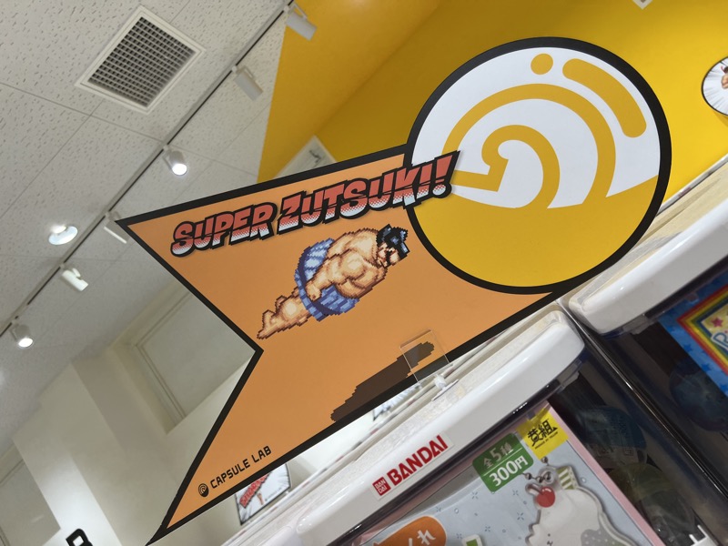 Gacha capsule machine with Super Zutsuki sumo character illustration