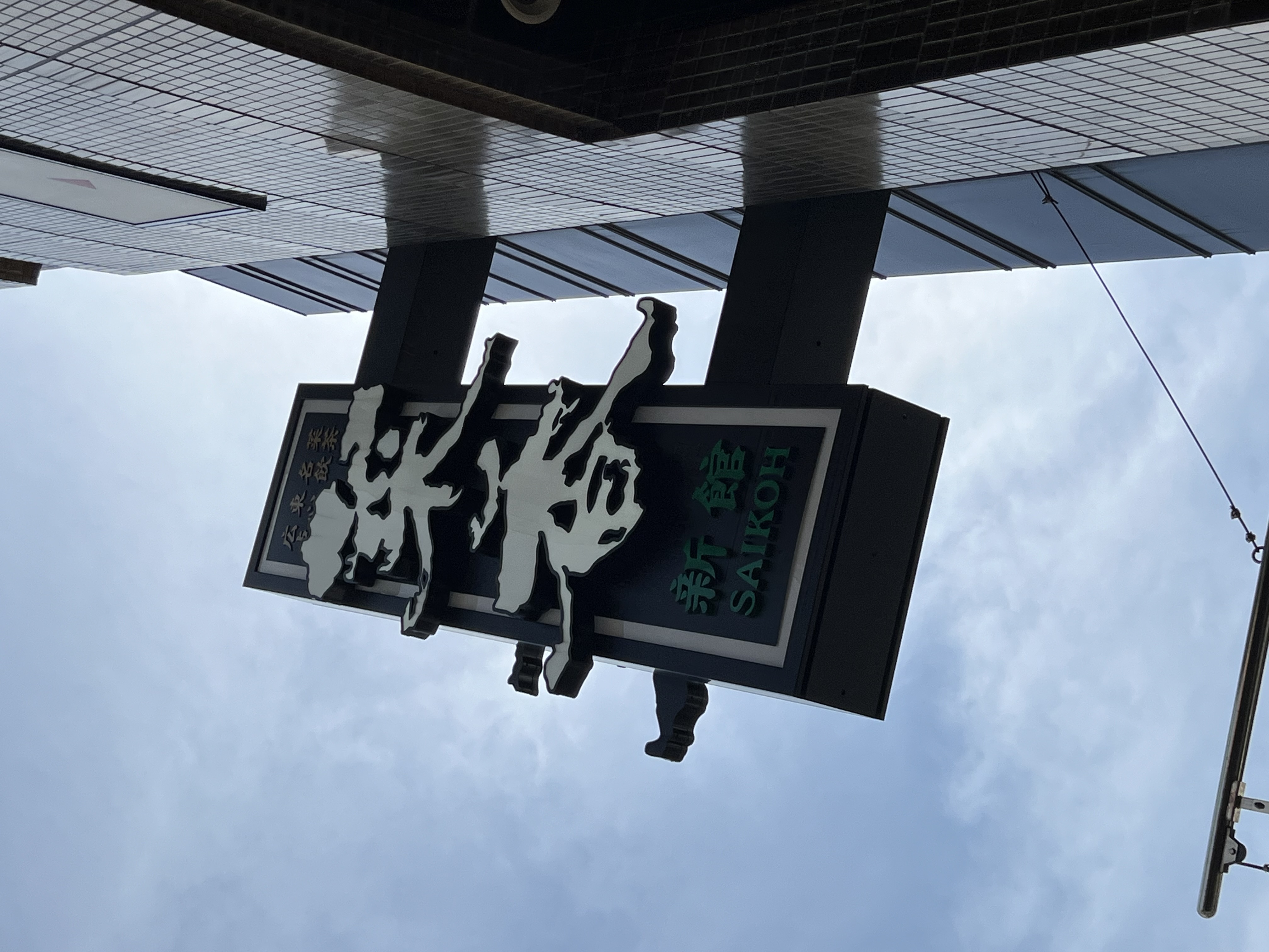 Saikoh Shinkan restaurant sign viewed from below