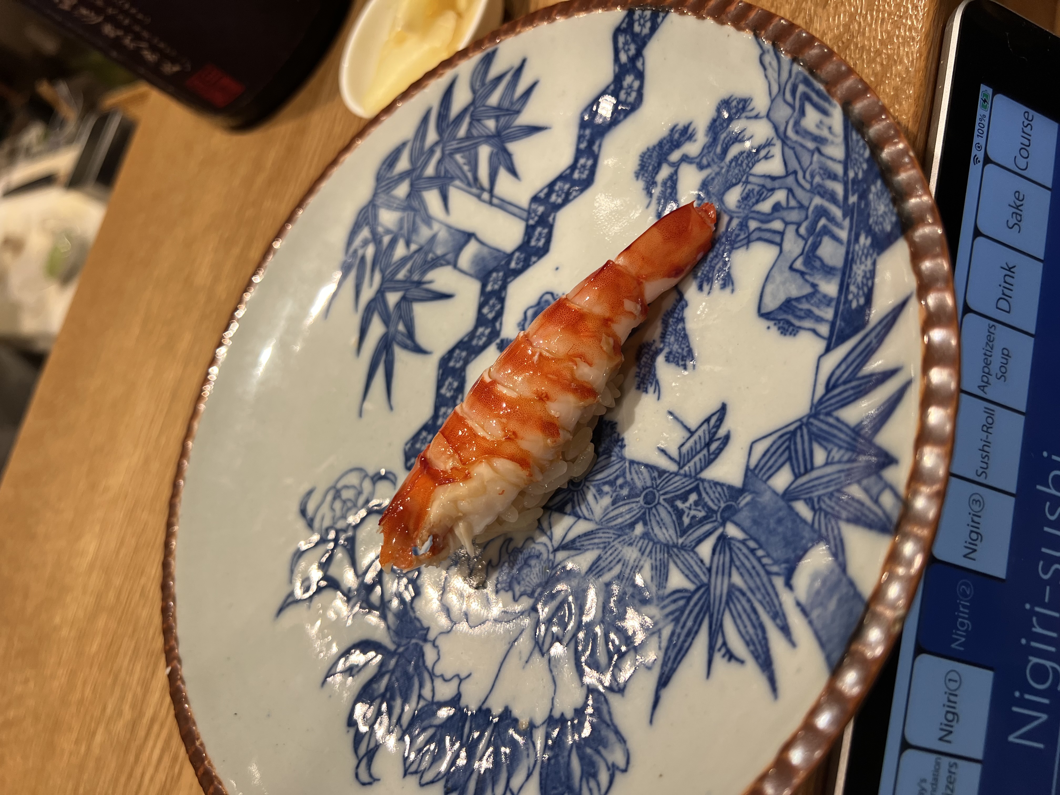 Prawn nigiri on a hand-painted blue and white ceramic plate
