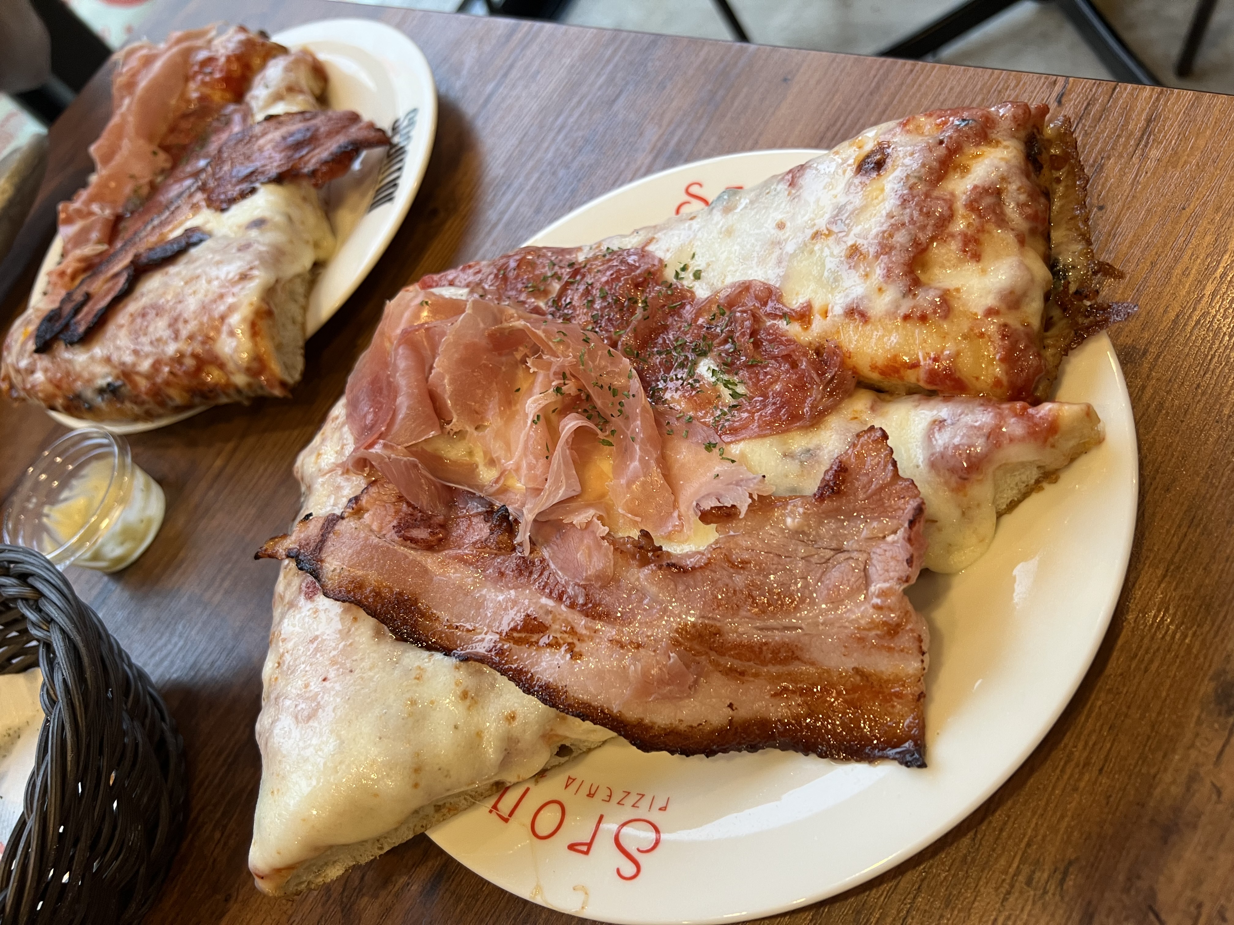 Pizzeria Spontini slices — thick crust, prosciutto, melted cheese