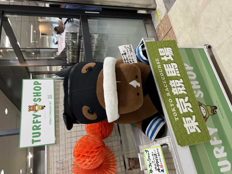 Turfy the mascot in full costume outside the Tokyo Racecourse shop