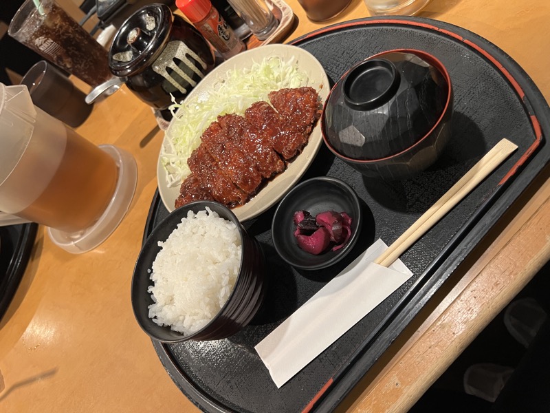 Miso katsu set on a black lacquered tray with rice, pickles and a beer
