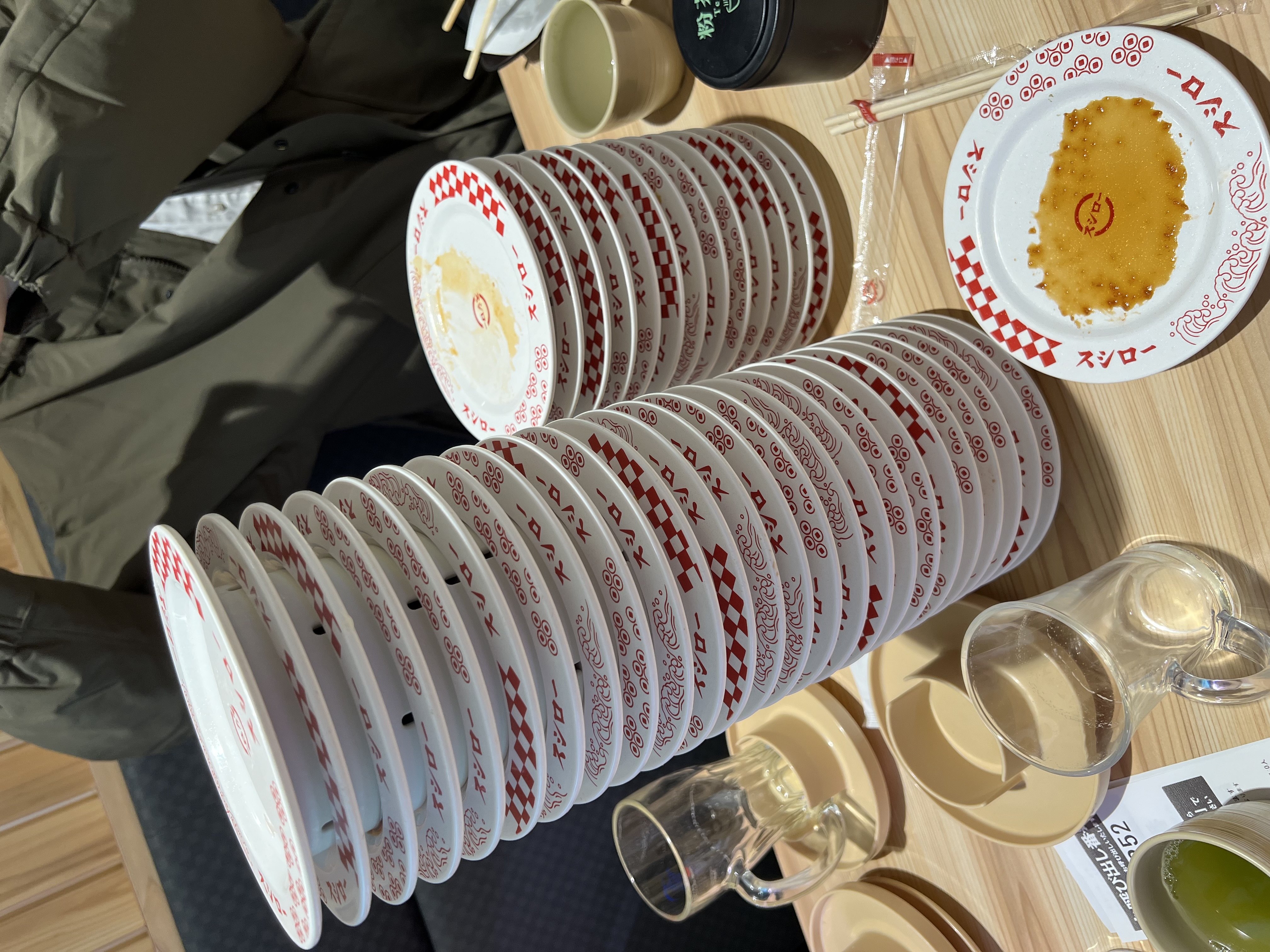 Tower of empty Sushiro plates stacked at the end of a meal