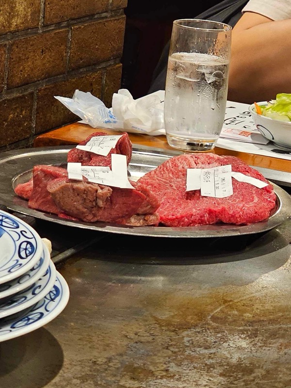 Raw wagyu cuts on a metal tray at a yakiniku restaurant