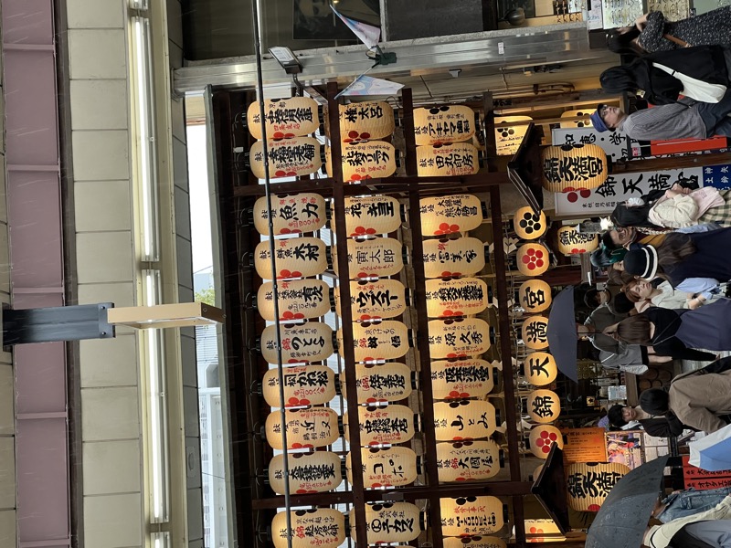 A wall of wooden sake barrels stacked high at Nishiki Market
